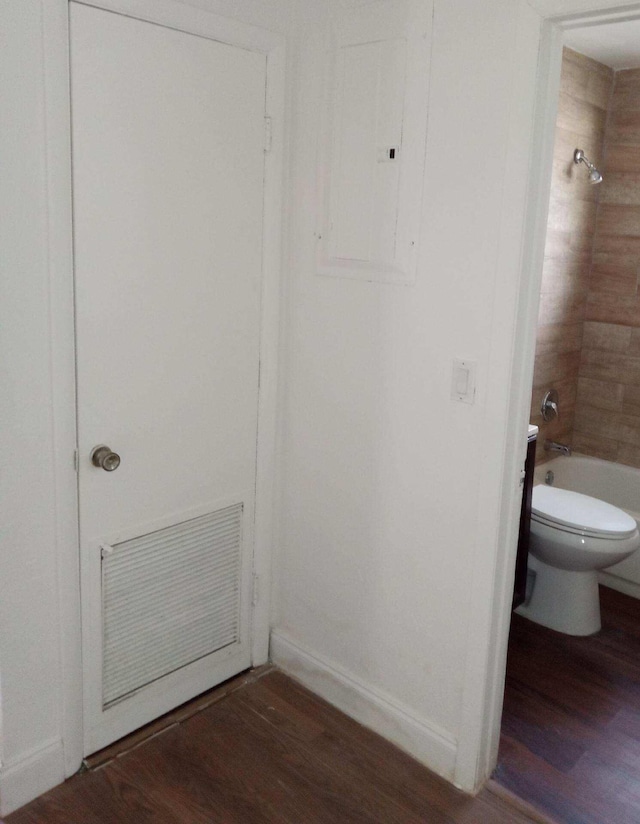 bathroom featuring toilet, wood-type flooring, and tub / shower combination