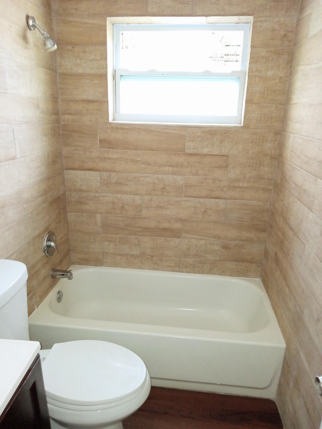 full bathroom featuring toilet, vanity, tiled shower / bath, and a wealth of natural light