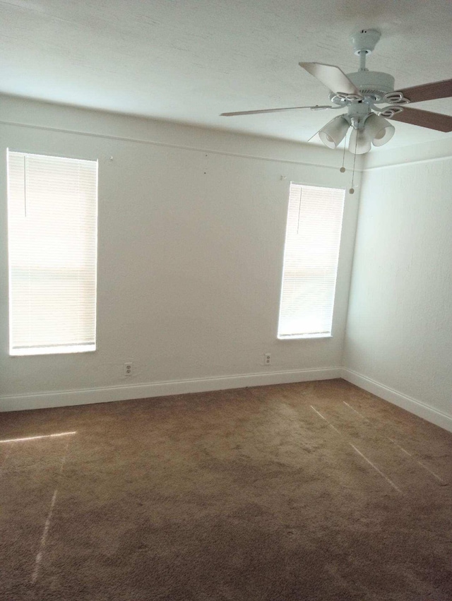 carpeted spare room with ceiling fan