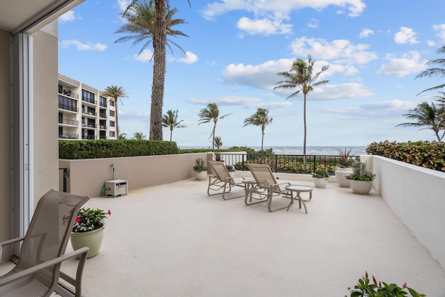 view of patio with a balcony and a water view