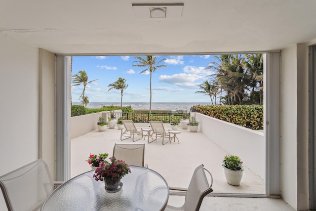 sunroom featuring a water view