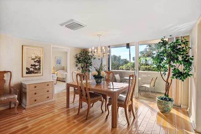 dining room with a notable chandelier and light hardwood / wood-style flooring