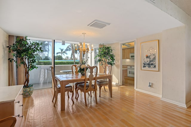 dining room with an inviting chandelier and light wood-type flooring