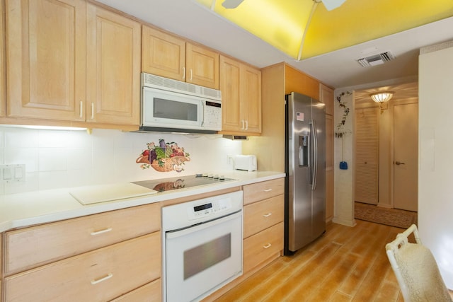 kitchen with backsplash, light brown cabinetry, light hardwood / wood-style floors, and white appliances