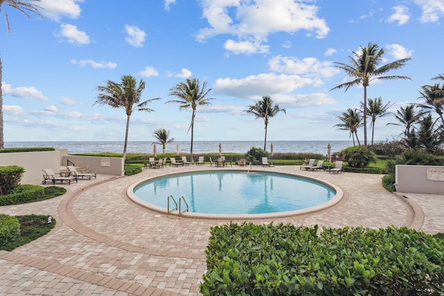 view of swimming pool with a patio and a water view