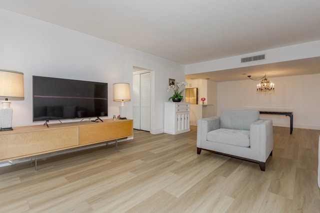 living room featuring a notable chandelier and light wood-type flooring