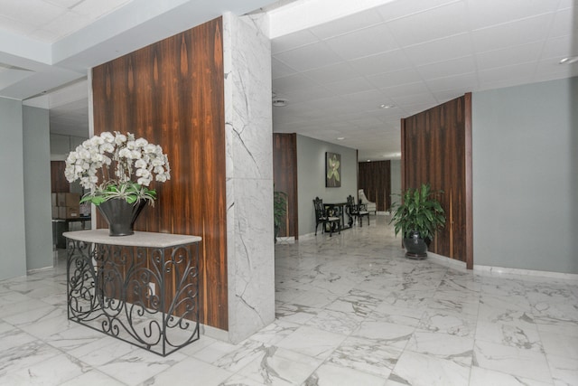 corridor with light tile patterned flooring and wood walls