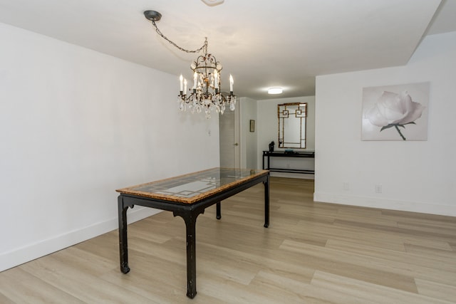 dining room featuring light wood-type flooring and a chandelier