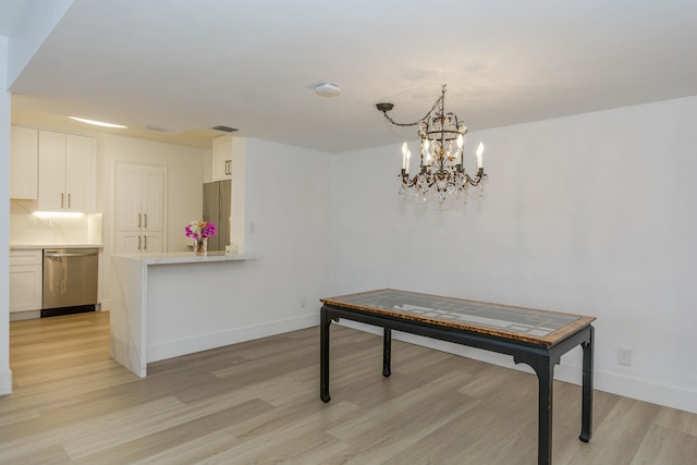 dining space featuring a notable chandelier and light hardwood / wood-style floors