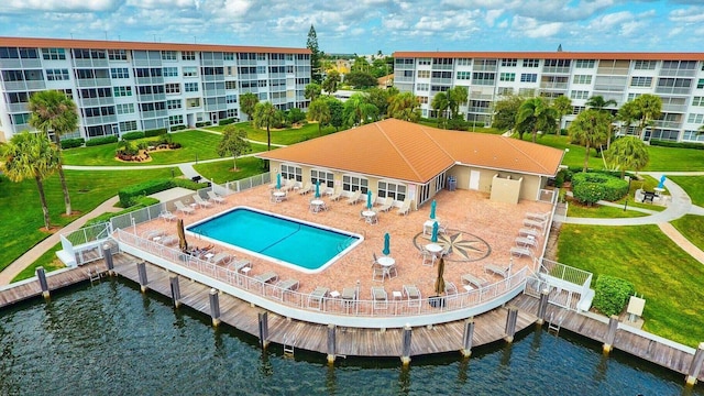 exterior space featuring a water view, a patio, a community pool, and a yard