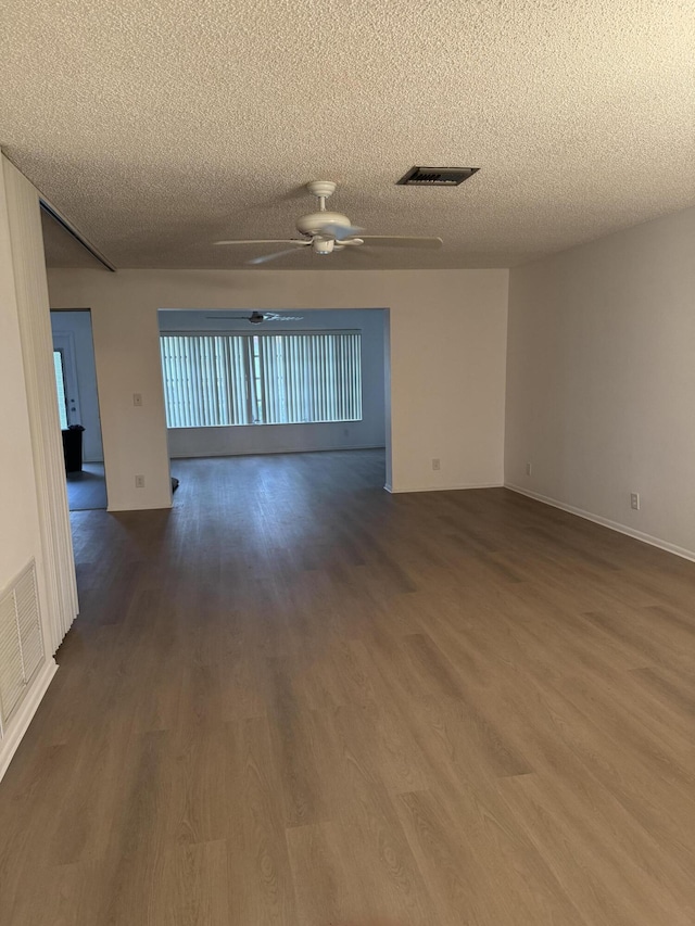 empty room with ceiling fan, a textured ceiling, and dark hardwood / wood-style flooring