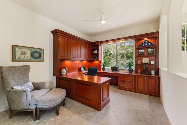 office space featuring ceiling fan, light tile floors, and built in desk