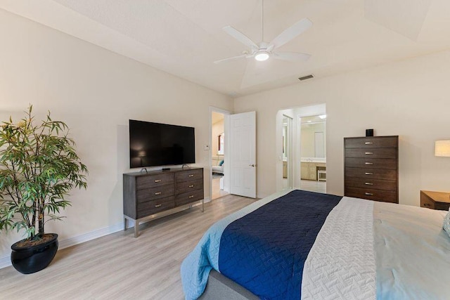 bedroom featuring ensuite bathroom, ceiling fan, and light wood-type flooring