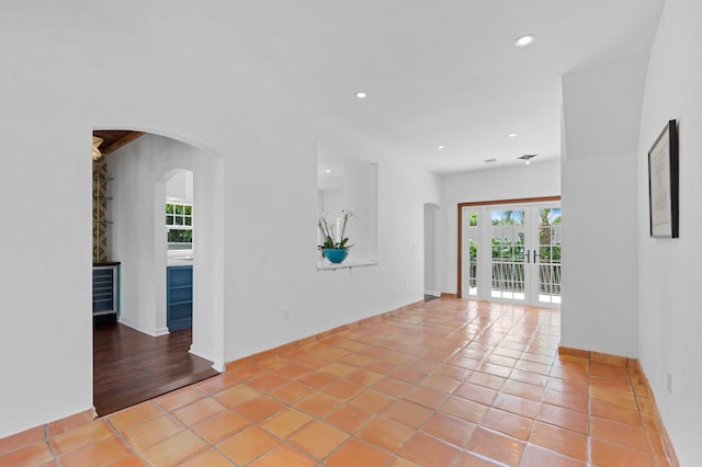 spare room featuring french doors and light tile patterned flooring