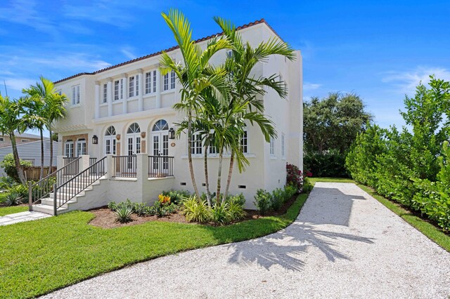 mediterranean / spanish-style home with a front lawn