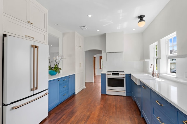 kitchen featuring dark hardwood / wood-style flooring, high end fridge, stainless steel range, blue cabinetry, and white cabinetry