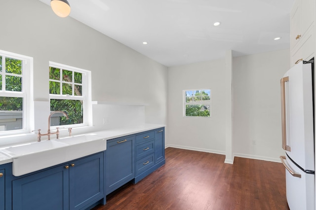 kitchen with white refrigerator, sink, and a wealth of natural light