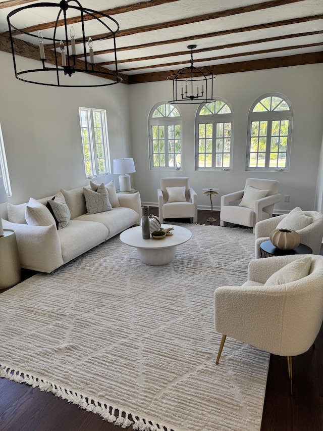 living room featuring hardwood / wood-style floors, beamed ceiling, and an inviting chandelier