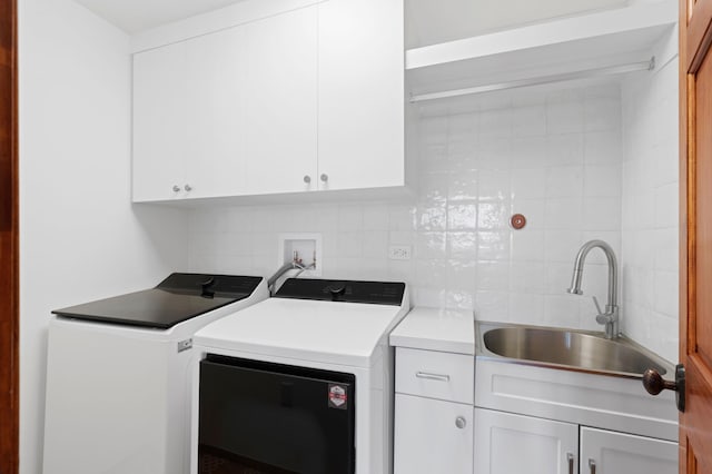 washroom with washer and clothes dryer, sink, and cabinets