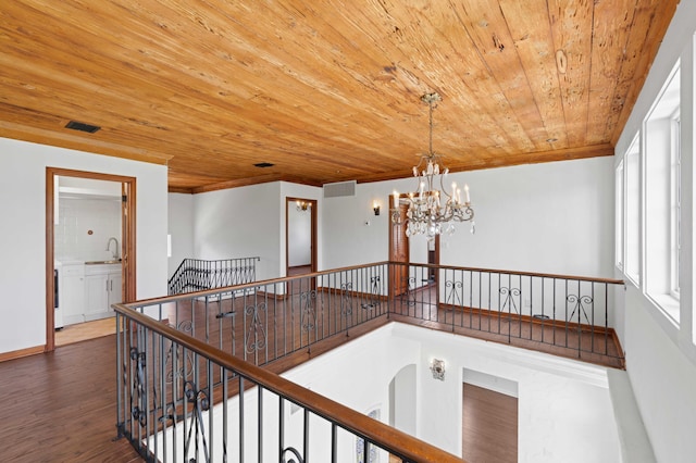 corridor featuring sink, wooden ceiling, dark hardwood / wood-style floors, and a notable chandelier