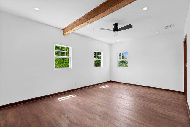 unfurnished room featuring ceiling fan, a healthy amount of sunlight, dark hardwood / wood-style flooring, and beam ceiling