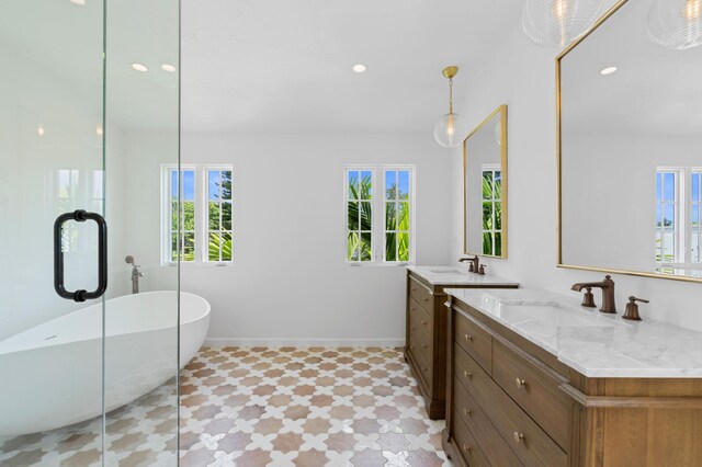 bathroom with vanity, a wealth of natural light, and a tub