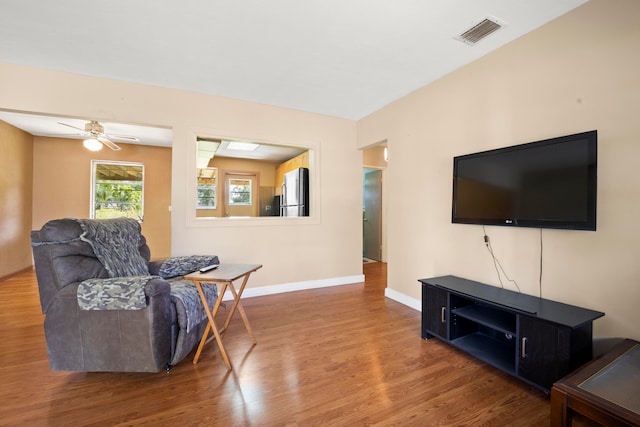 living room featuring hardwood / wood-style floors and ceiling fan