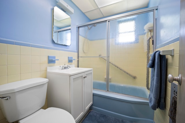 full bathroom with tile walls, toilet, enclosed tub / shower combo, backsplash, and large vanity