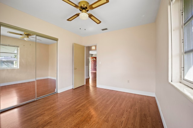 unfurnished bedroom featuring a closet, ceiling fan, and dark wood-type flooring