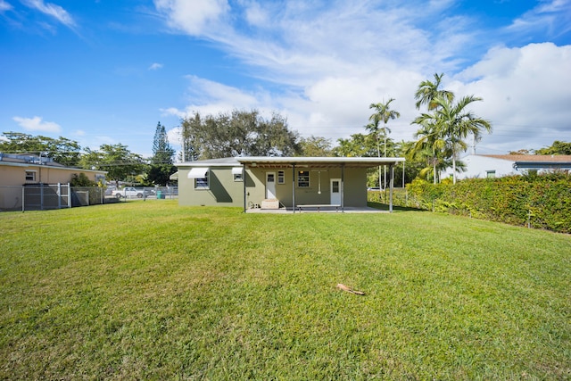 rear view of property with a yard and a patio