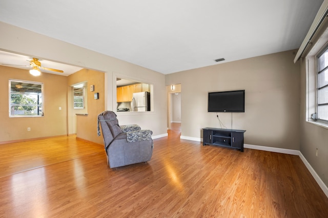 living room featuring ceiling fan and light wood-type flooring