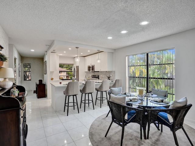 tiled dining area featuring a textured ceiling