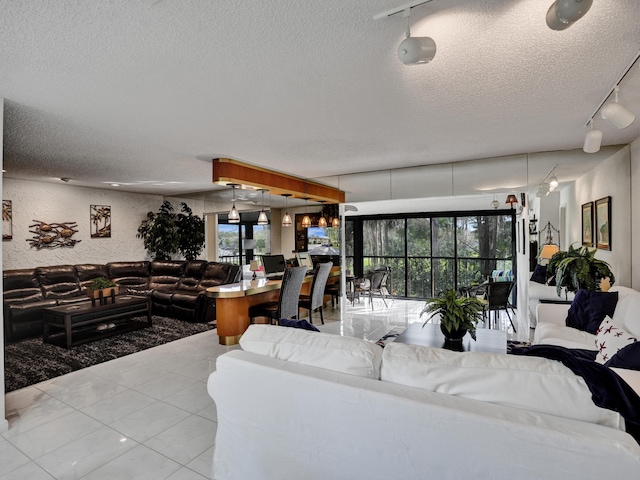 tiled living room with a textured ceiling, rail lighting, and a healthy amount of sunlight