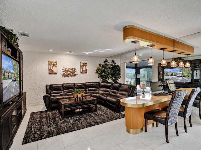 interior space with a textured ceiling and light tile flooring