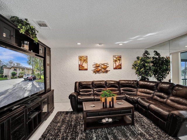 living room featuring a textured ceiling and light tile flooring