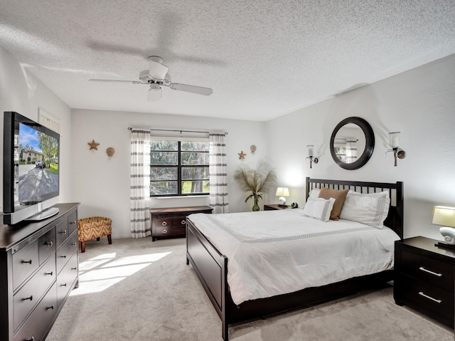 bedroom with light carpet, a textured ceiling, and ceiling fan