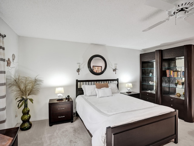 bedroom with light carpet, a textured ceiling, and ceiling fan