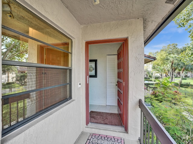 view of exterior entry with a balcony