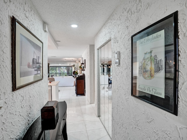 corridor with light tile floors and a textured ceiling