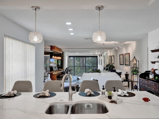 kitchen featuring hanging light fixtures, a chandelier, and light stone counters