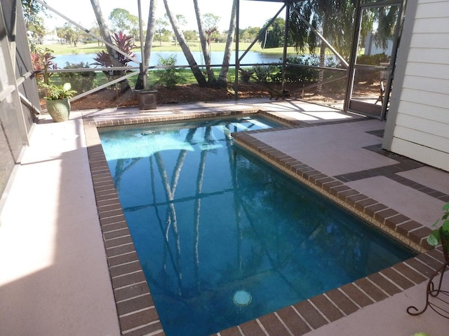 view of swimming pool featuring a patio and glass enclosure