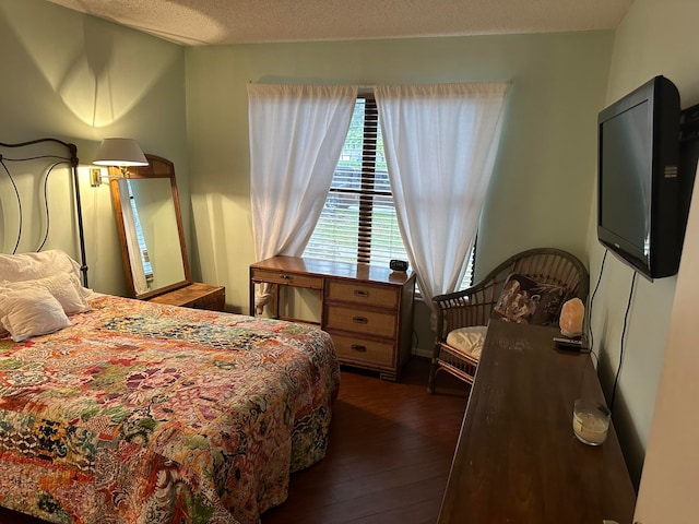 bedroom with a textured ceiling and dark hardwood / wood-style floors