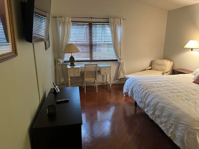 bedroom featuring multiple windows and dark hardwood / wood-style floors