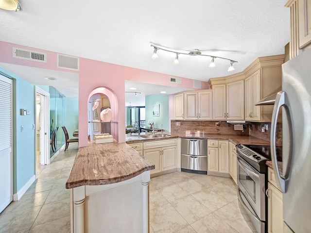 kitchen featuring tasteful backsplash, stainless steel appliances, light tile floors, and light stone counters