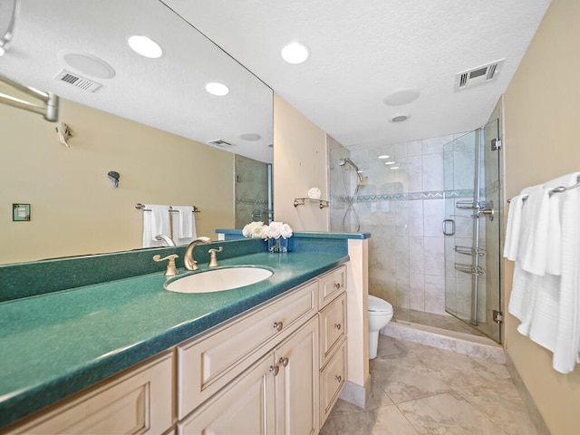 bathroom featuring an enclosed shower, vanity, tile floors, a textured ceiling, and toilet