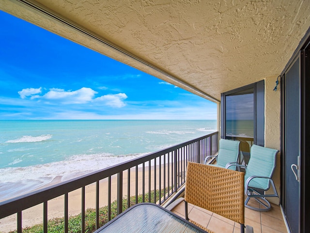 balcony with a beach view and a water view