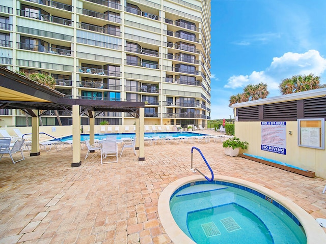 view of swimming pool with a hot tub