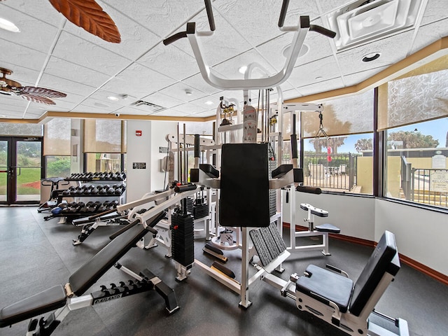 workout area with a paneled ceiling, plenty of natural light, and ceiling fan