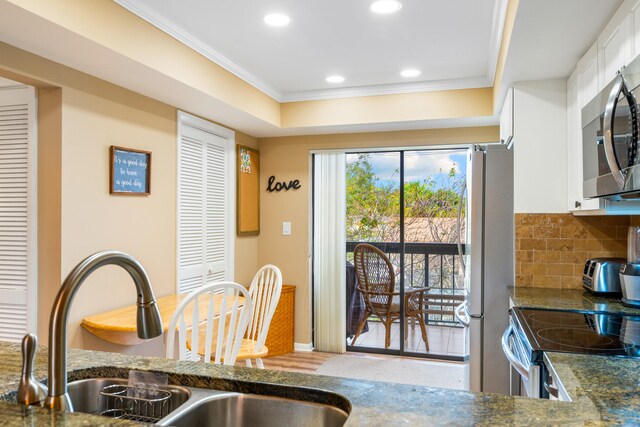 kitchen featuring stainless steel appliances, white cabinets, and dark stone counters