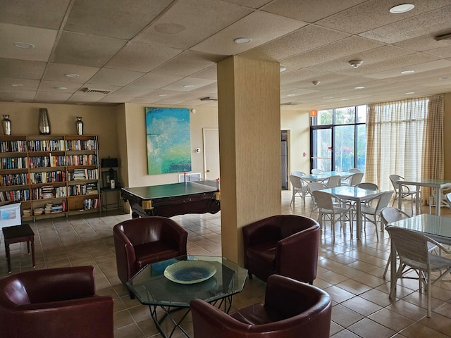 interior space with tile floors and a paneled ceiling